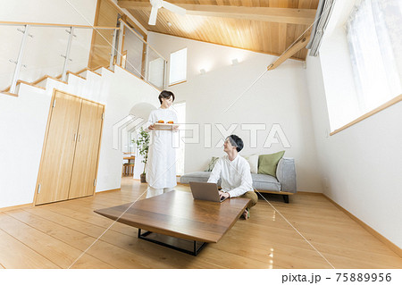 吹き抜けリビングでテレワークする男性 吹き抜けリビングでテレワークする男性 75889956