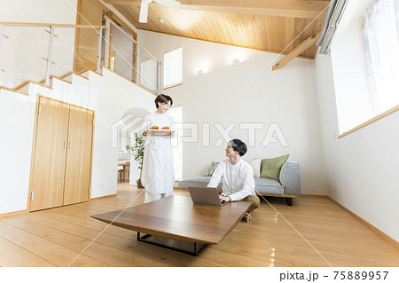 吹き抜けリビングでテレワークする男性 75889957