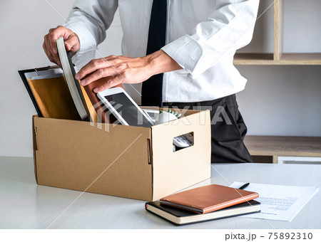 Images of businessman carrying packing up all his personal belongings and files into a brown cardboard box has frustrated and stressed to resignation and signing cancellation contract letter 75892310