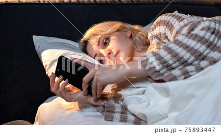Young girl with smartphone in a bed Young girl with smartphone in a bed 75893447
