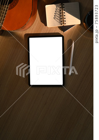 Digital tablet, notebook and acoustic guitar on wooden floor. 75893723