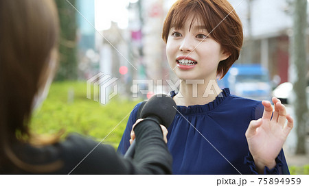 街頭インタビューを受ける女性 75894959