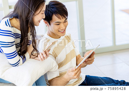 カップルでスマホとタブレットを操作している カップルでスマホとタブレットを操作している 75895428