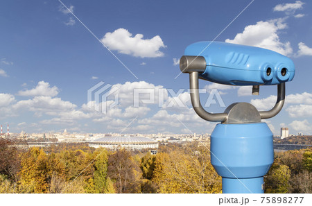 Touristic telescope viewer (binoculars) and view of central Moscow from Sparrow Hills or Vorobyovy Gory observation (viewing) platform-- is on a steep bank 85 m above the Moskva river, or 200 m above 75898277