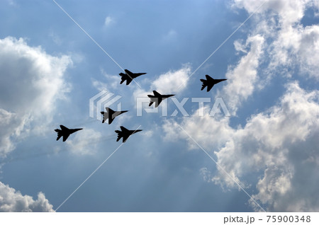 Flight of modern combat fighters on the sky background Flight of modern combat fighters on the sky background 75900348