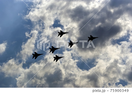 Flight of modern combat fighters on the sky background 75900349