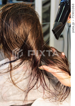 Young girl, hairdresser dries her hair with a hairdryer in a beauty salon 75901068