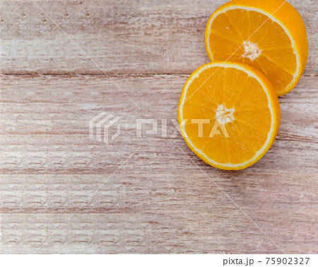 Orange halves on a wooden background. Orange halves on a wooden background. 75902327