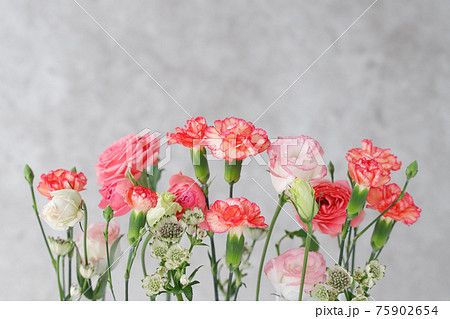 グレーのアンティークな背景にバラとカーネーションの花の写真素材