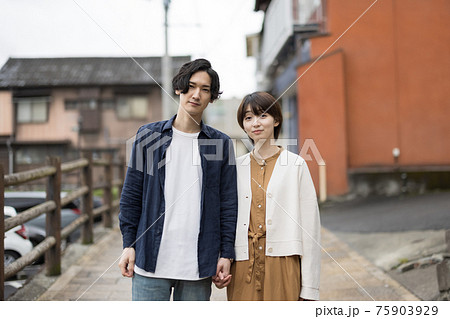 手をつないで微笑む若いカップル 手をつないで微笑む若いカップル 75903929
