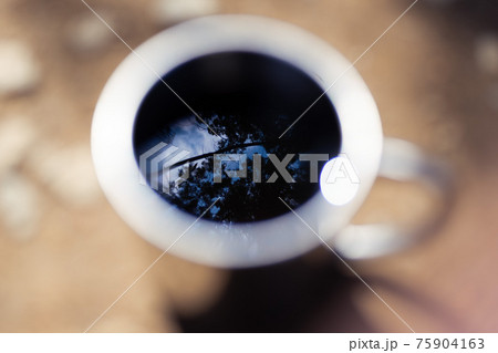 山コーヒーに映り込む空 75904163