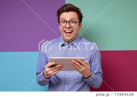 Happy caucasian man in glasses using digital tablet Happy caucasian man in glasses using digital tablet 75904426
