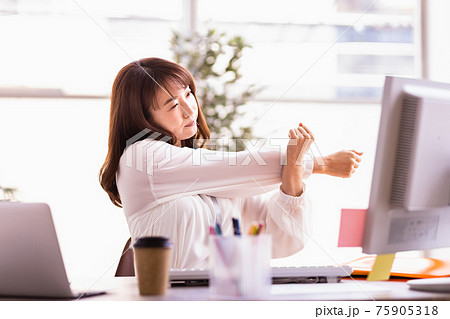 デスクワーク中にストレッチをする女性 75905318