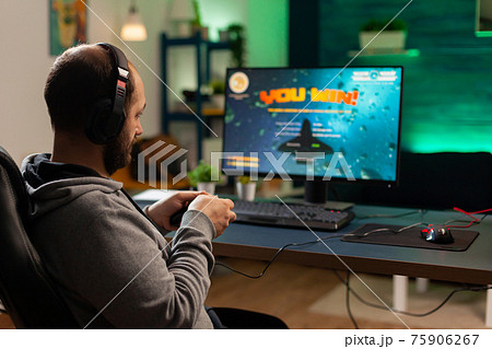 Back shot of pro gamer playing online shooter game Back shot of pro gamer playing online shooter game 75906267