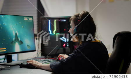 Pro woman video game r using headset playing online space shooter video games 75906458