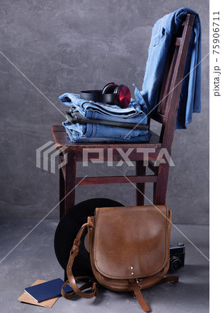 Denim jeans at wooden table near grey wall background texture Denim jeans at wooden table near grey wall background texture 75906711