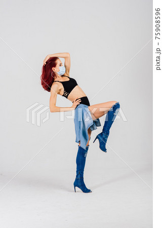 Female dancer in the styles of strip-plastic and pole dance with face mask on light background. 75908596