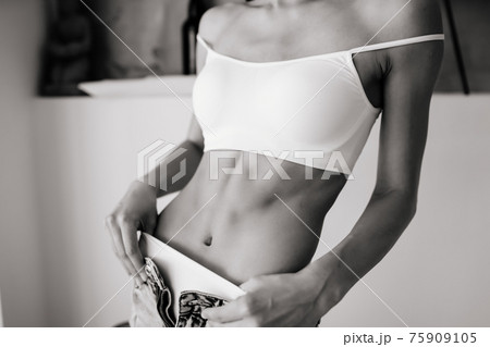 Young woman is taking her jeans off. 75909105