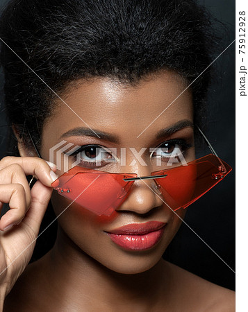 Young beautiful black woman wearing red sunglasses Young beautiful black woman wearing red sunglasses 75912928