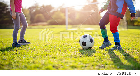 Children playing football on the field with gates. 75912947