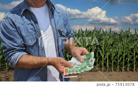 Agricultural concept, farmer, money and corn field Agricultural concept, farmer, money and corn field 75913078