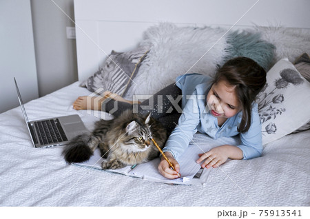 Distance learning online education. Schoolgirl with digital tablet laptop notebook and doing school 75913541