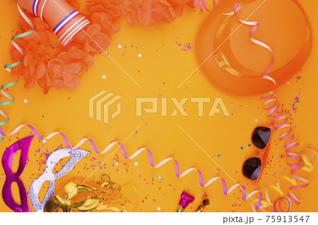 Decor for a traditional celebration of King's Day in the Netherlands. Orange hat, glasses, jewelry 75913547