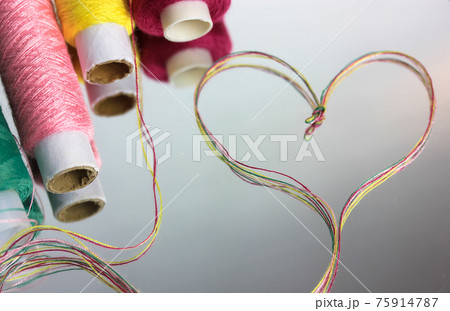 A heart of multicolored thread on the surface of the mirror. Heart shape threads 75914787