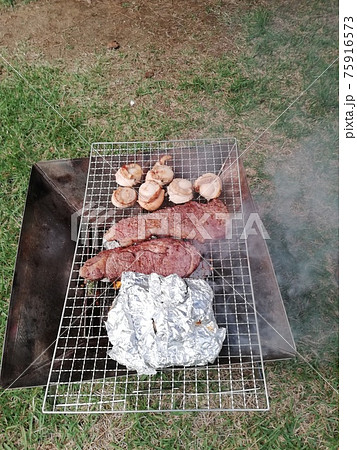 キャンプ場でBBQ、ステーキを焼く キャンプ場でBBQ、ステーキを焼く 75916573