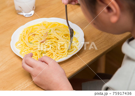 お昼ごはんにカルボナーラを食べる子供 75917436