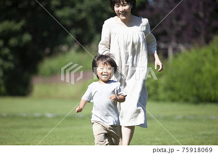 公園で鬼ごっこをする親子 75918069