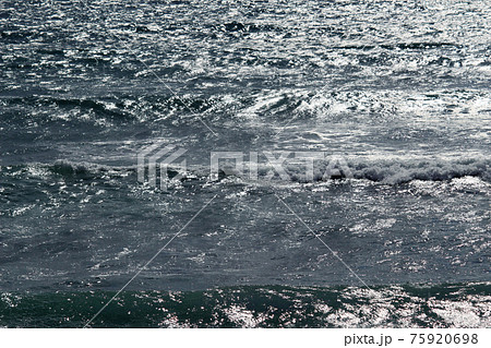 日差しでキラキラ光る海の背景素材用写真の写真素材