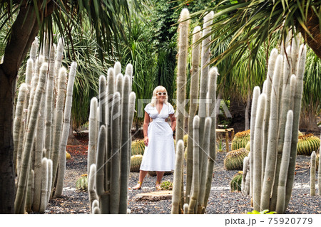 A girl in a white dress on the background of huge cacti on the island of Tenerife.Spain 75920779