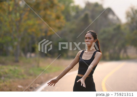 Healthy young asian woman in sportswear exercises outdoors in the evening. Healthy young asian woman in sportswear exercises outdoors in the evening. 75921311