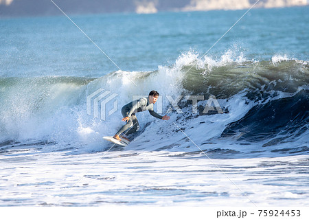 湘南の海でサーフィンをする男性 75924453