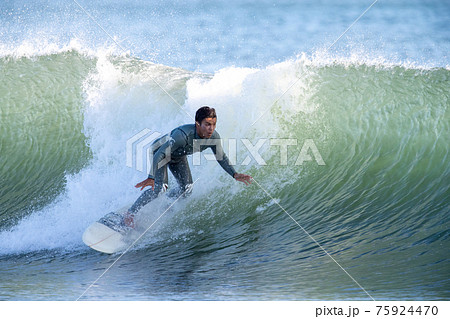 湘南の海でサーフィンをする男性 75924470