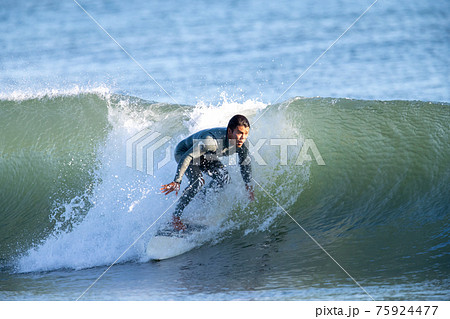 湘南の海でサーフィンをする男性 75924477