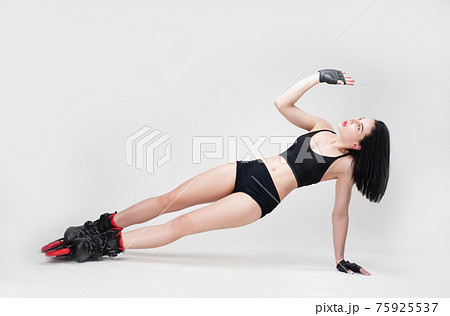 a slender woman in sportswear on roller skates on a white background stands on a stretched side plank a slender woman in sportswear on roller skates on a white background stands on a stretched side plank 75925537