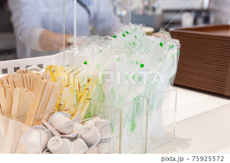 飲食店のカウンターに置かれたプラスチックスプーン、木製マドラー、コーヒーミルク 飲食店のカウンターに置かれたプラスチックスプーン、木製マドラー、コーヒーミルク 75925572