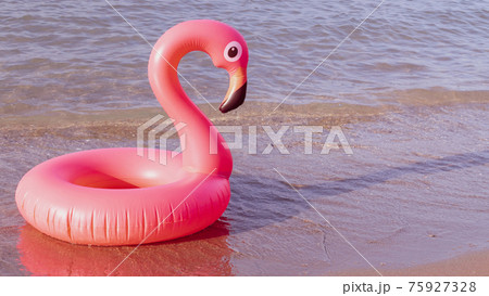 Hello summer. Pink inflatable flamingo in blue ocean water for sea summer beach background. Trendy summer concept. 75927328