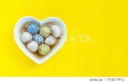Black sesame dumpling in ginger tea recipes on yellow background. Black sesame dumpling in ginger tea recipes on yellow background. 75927451