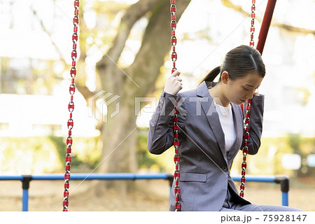 公園でたそがれる若い女性　スーツ 75928147