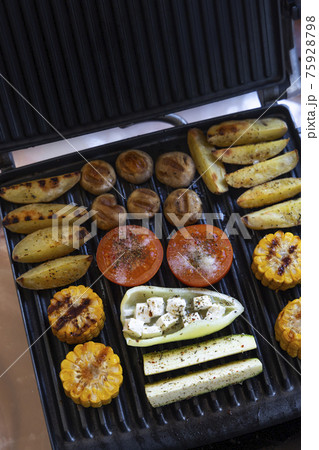Electric grill with spicy potatoes, mushrooms and vegetables Electric grill with spicy potatoes, mushrooms and vegetables 75928798