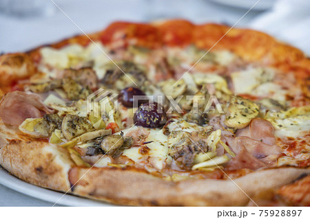 homemade pizza with ham, olives and artichoke 75928897