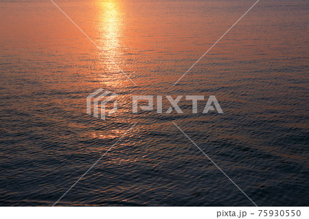 夕焼けの反射する水面 75930550