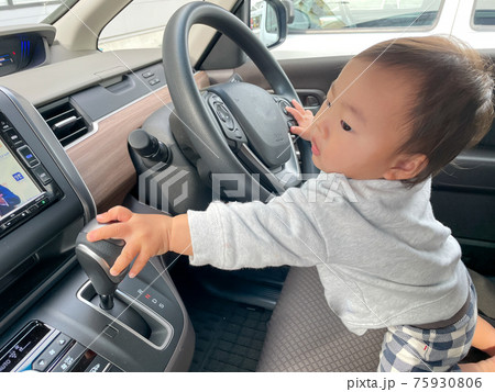 車の運転に挑戦する男の子の赤ちゃん 75930806