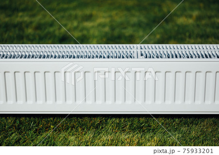 radiator on green lawn, ecological heating concept radiator on green lawn, ecological heating concept 75933201