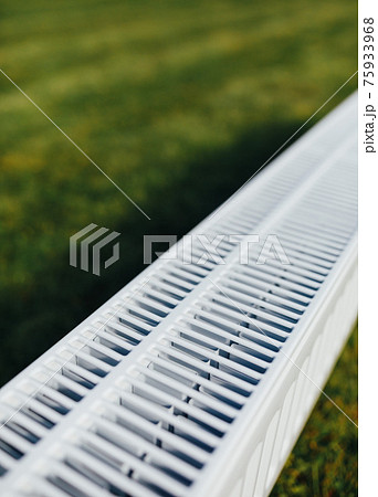 radiator mesh, green lawn background, ecological heating concept radiator mesh, green lawn background, ecological heating concept 75933968