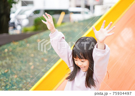 滑り台で遊ぶ小さな女の子 75934497