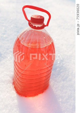 bottle with non-freezing windshield washer fluid, snow background bottle with non-freezing windshield washer fluid, snow background 75936020